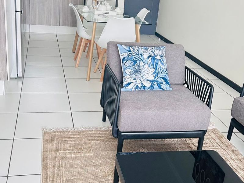 Open-plan living and kitchen area featuring modern cabinetry, tiled flooring, and a functional layout suitable for contemporary apartment living.