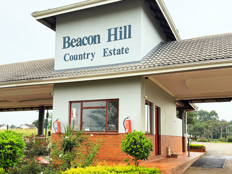 The entrance gatehouse to Beacon Hill Country Estate, featuring a brick and plaster facade with a tiled roof and security infrastructure.