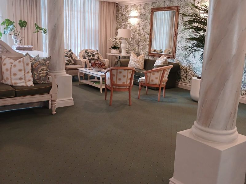 A well-maintained communal living area featuring decorative columns, recessed lighting, and elegant wallpaper, creating a comfortable and inviting space for residents.