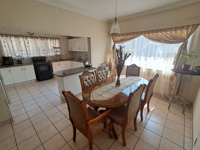 Open-plan kitchen and dining area featuring tiled flooring, built-in cabinetry, and a kitchen peninsula, offering a functional layout for daily living.