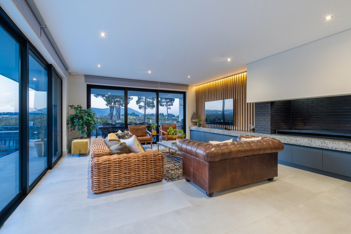 Modern living room featuring a timber slat feature wall, built-in fireplace with stone hearth, recessed lighting, and large sliding glass doors opening to the patio.