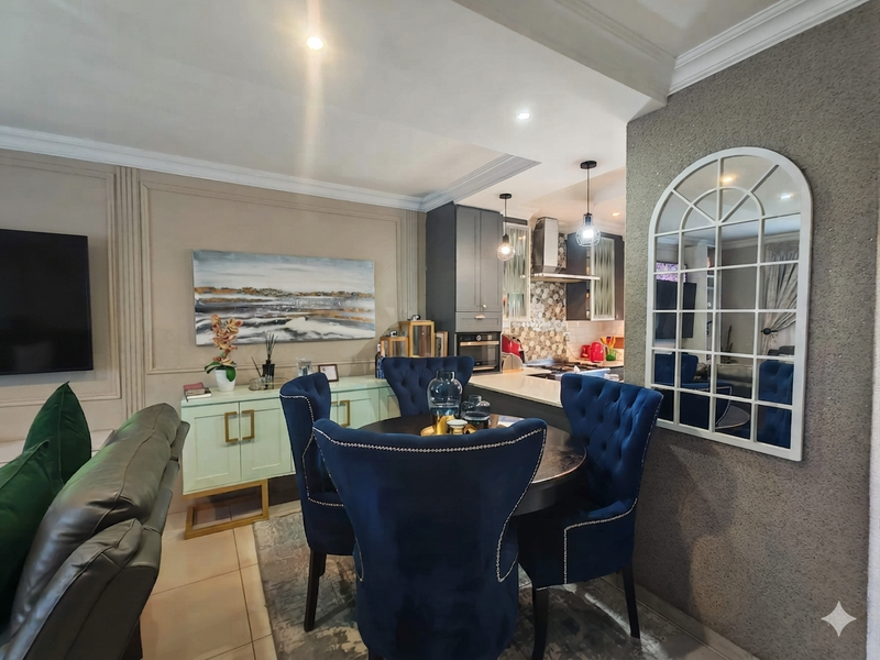 An open-plan living and dining area featuring elegant wall paneling, recessed lighting, and a modern kitchen with built-in cabinetry and appliances.