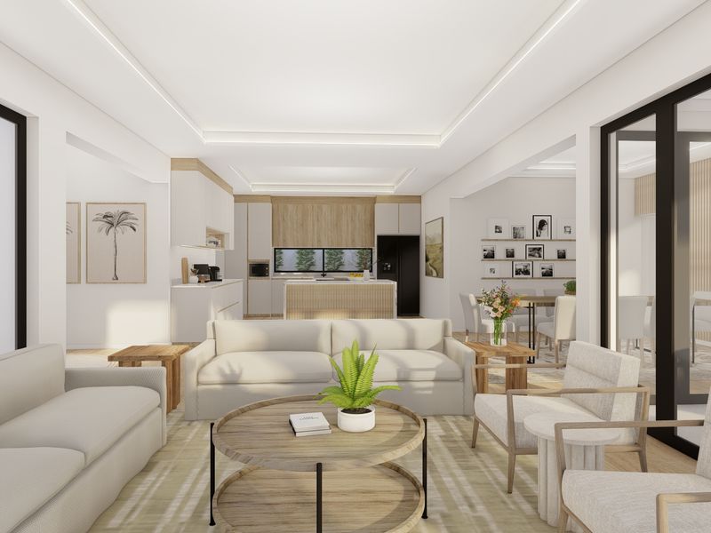 A bright, modern open-plan living and kitchen area featuring contemporary cabinetry, a central island, and seamless access to outdoor spaces through large sliding doors.