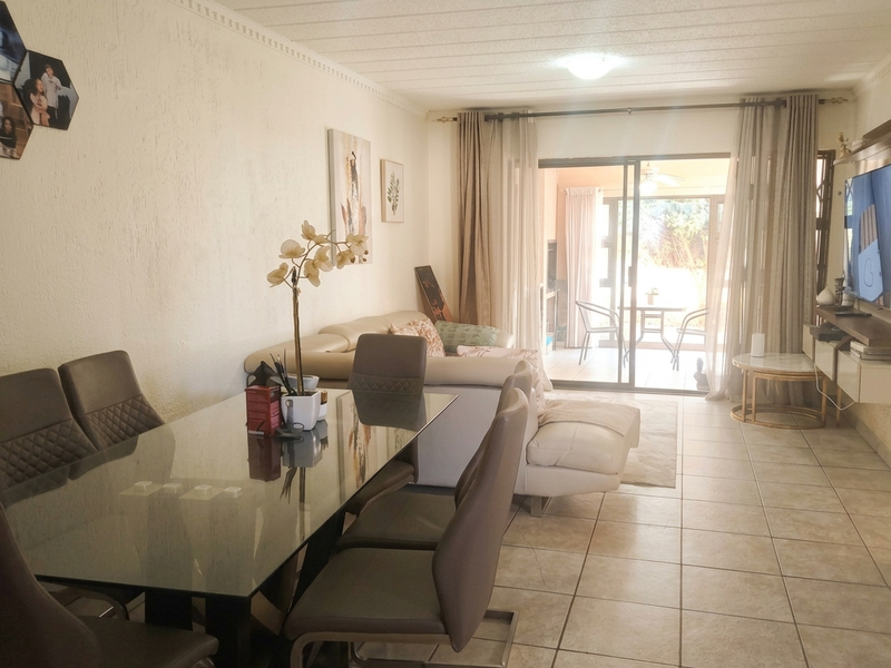 Open-plan living and dining area featuring tiled flooring and sliding glass doors that provide direct access to an outdoor patio space.