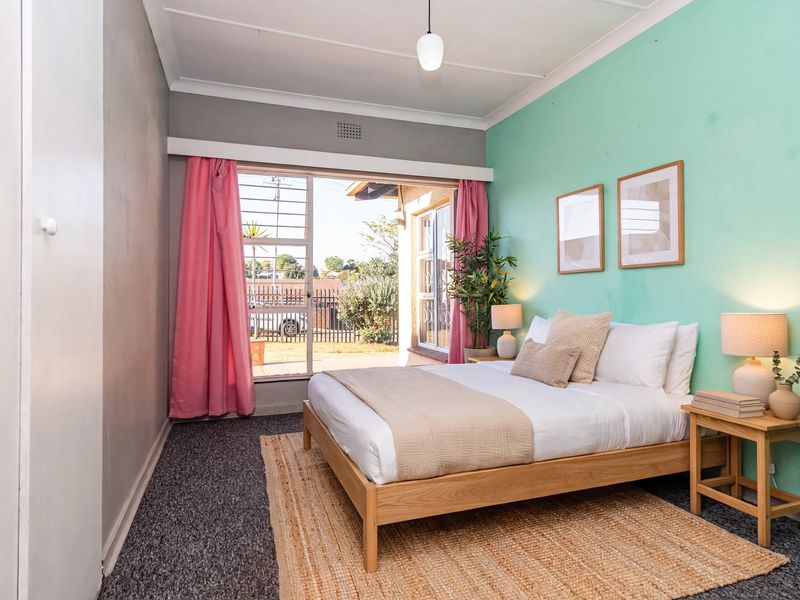 A bedroom featuring a built-in wardrobe, sliding glass door with security gate, and direct access to the exterior.