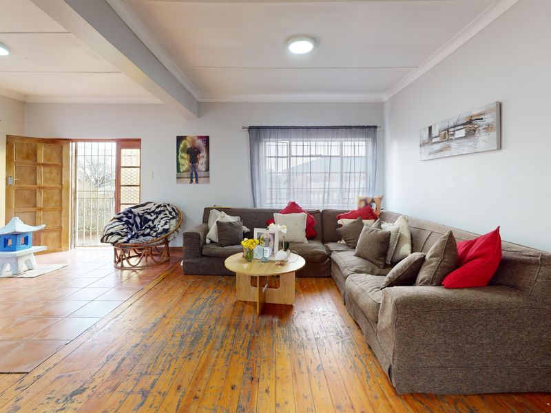 Spacious living area featuring a combination of timber and tiled flooring, with direct access to an outdoor area through a security gate.