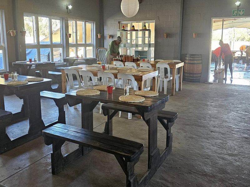 Spacious open-plan dining area featuring exposed concrete block walls, polished concrete floors, and large windows providing ample natural light.