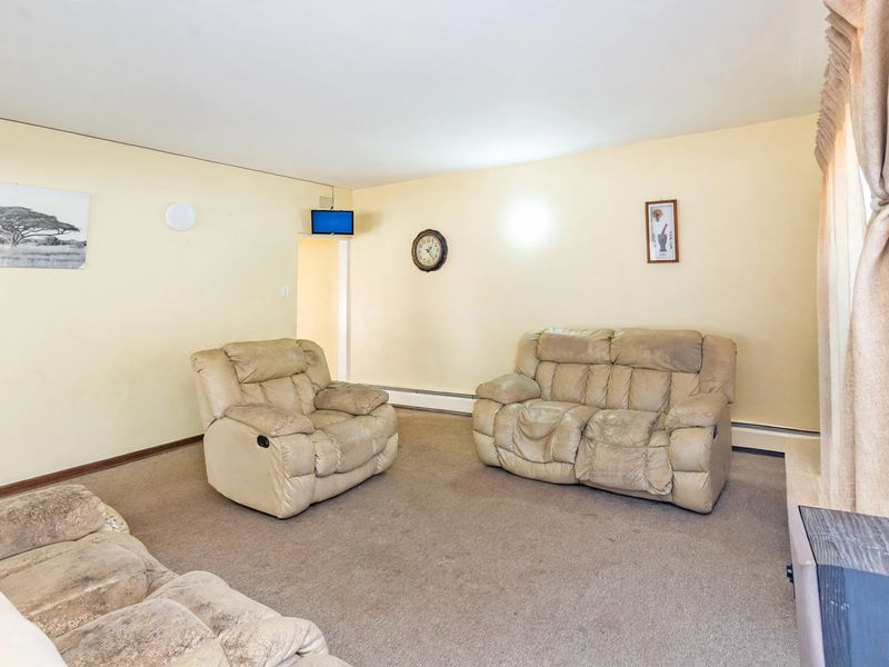 A living room featuring carpeted flooring and neutral wall finishes, offering a blank canvas for potential updates and modernization.