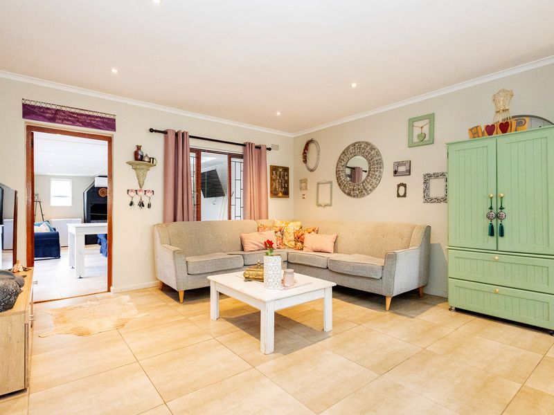 A well-maintained living room featuring neutral tiled flooring and recessed downlighting, offering a comfortable and inviting space for relaxation.