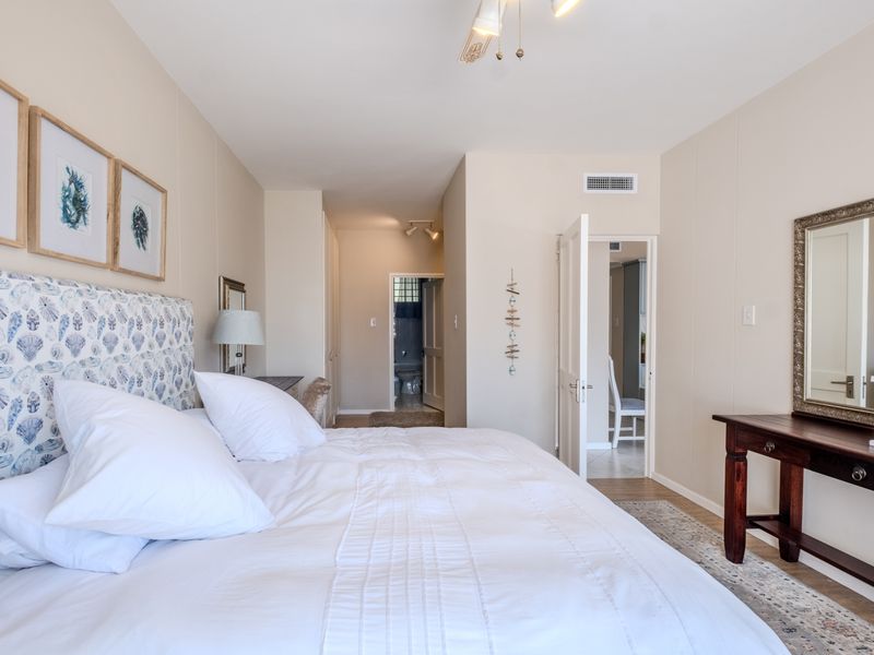 A well-maintained bedroom featuring neutral walls, built-in storage, and direct access to an adjoining bathroom.