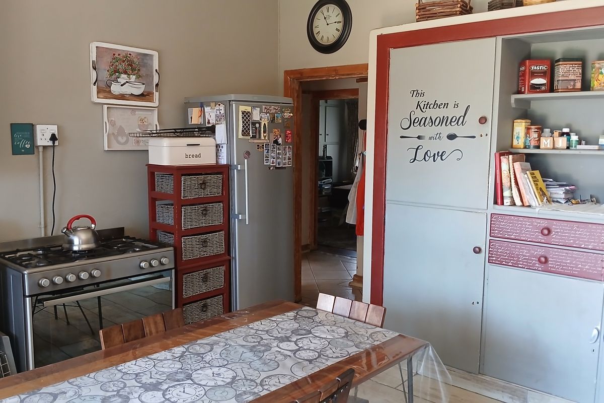 A functional kitchen featuring a gas stove, oven, and built-in cabinetry with a dining area.