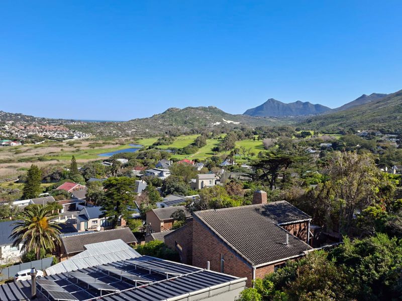 Elevated panoramic view overlooking a residential neighborhood, golf course, and surrounding mountain landscape.