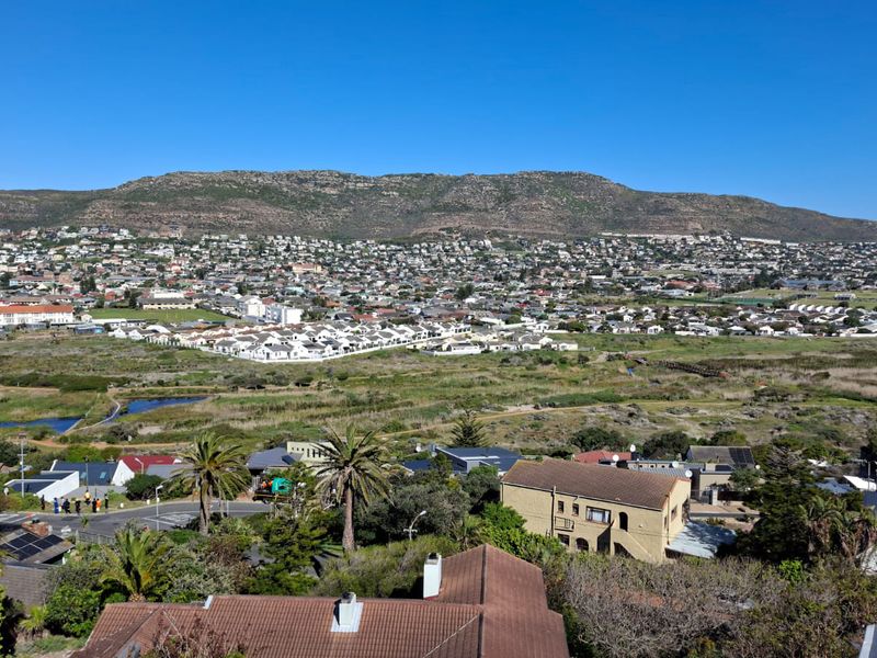 Elevated panoramic view overlooking the surrounding residential suburb, natural landscape, and distant mountain range.