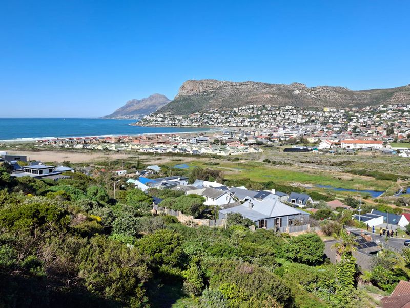 Elevated panoramic view overlooking the coastal town, surrounding wetlands, and distant mountain range.