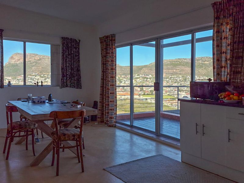 Open-plan living and dining area featuring large windows and sliding glass doors that provide expansive mountain and valley views.
