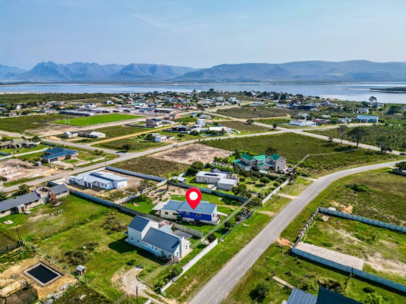 Aerial view of the property showing its position within the coastal residential estate, featuring surrounding landscape and proximity to the water.