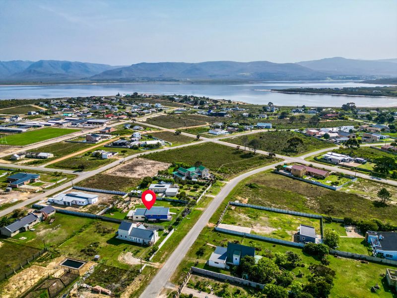 Aerial view of the residential property and surrounding neighborhood, showcasing the coastal location and proximity to the lagoon.