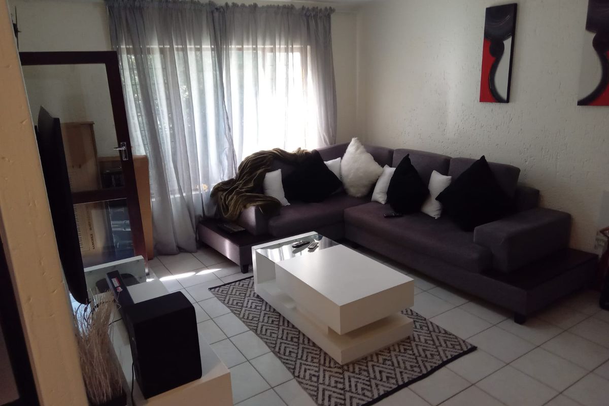 A comfortable living room featuring tiled flooring and textured wall finishes, providing a neutral base for interior design updates.