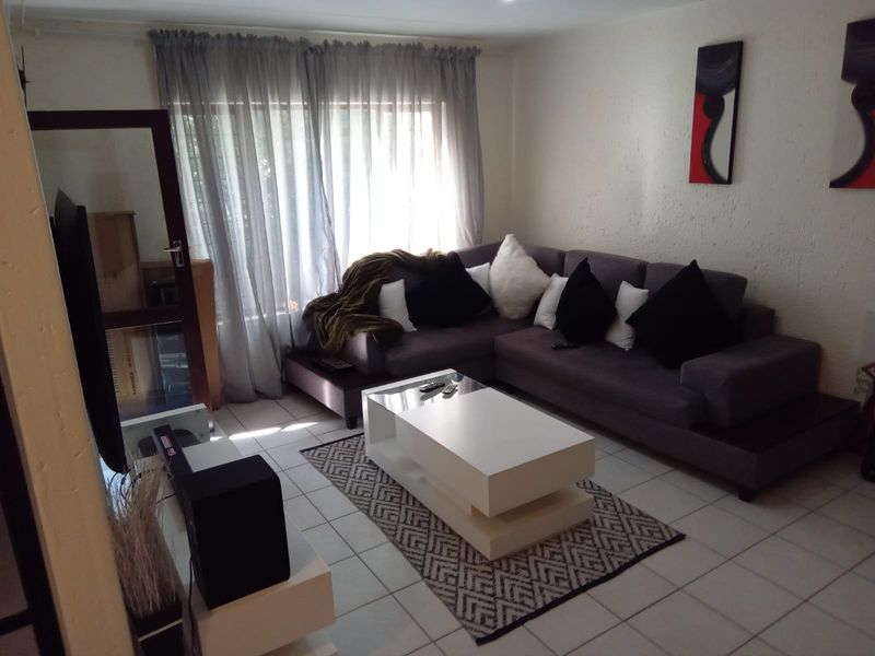 A comfortable living room featuring tiled flooring and textured wall finishes, providing a neutral base for interior design updates.
