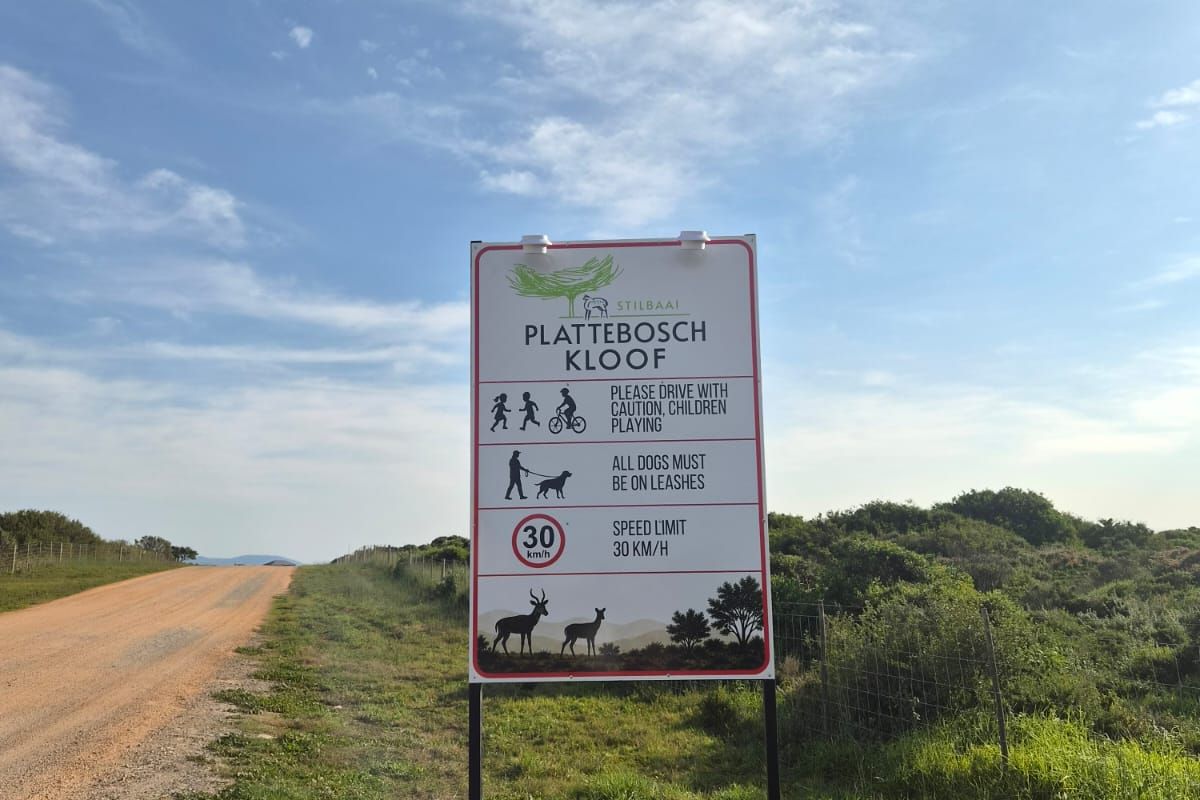 A view of the entrance road and estate signage for the Plattebosch Kloof residential area.