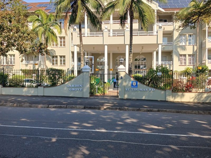 Front elevation of Garden Grove retirement village on St Thomas Road, featuring a multi-story building with balconies, solar panels, and secure gated entrance.