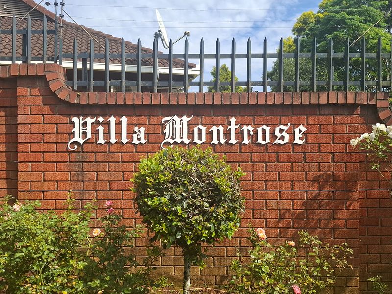 A view of the brick boundary wall and security fencing at the entrance of Villa Montrose townhouse complex.
