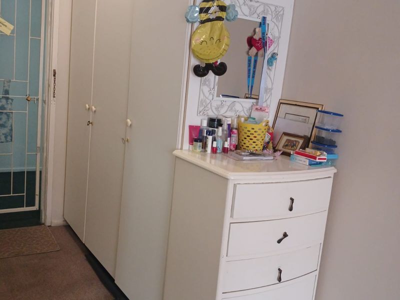 Bedroom featuring a tall built-in wardrobe and access to an adjacent area through a security gate.