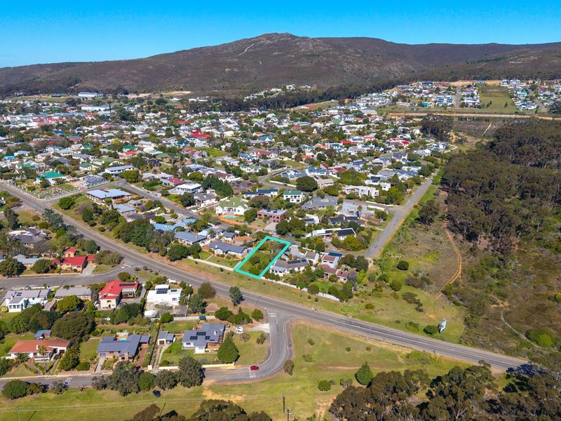 Aerial view of a vacant residential land plot highlighted in a suburban neighborhood setting with mountain views.