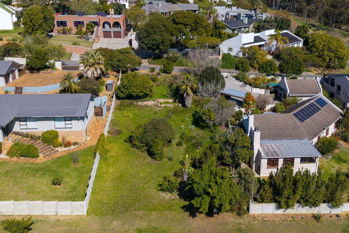Aerial view of a vacant residential land plot situated within an established neighborhood, surrounded by existing homes and mature landscaping.