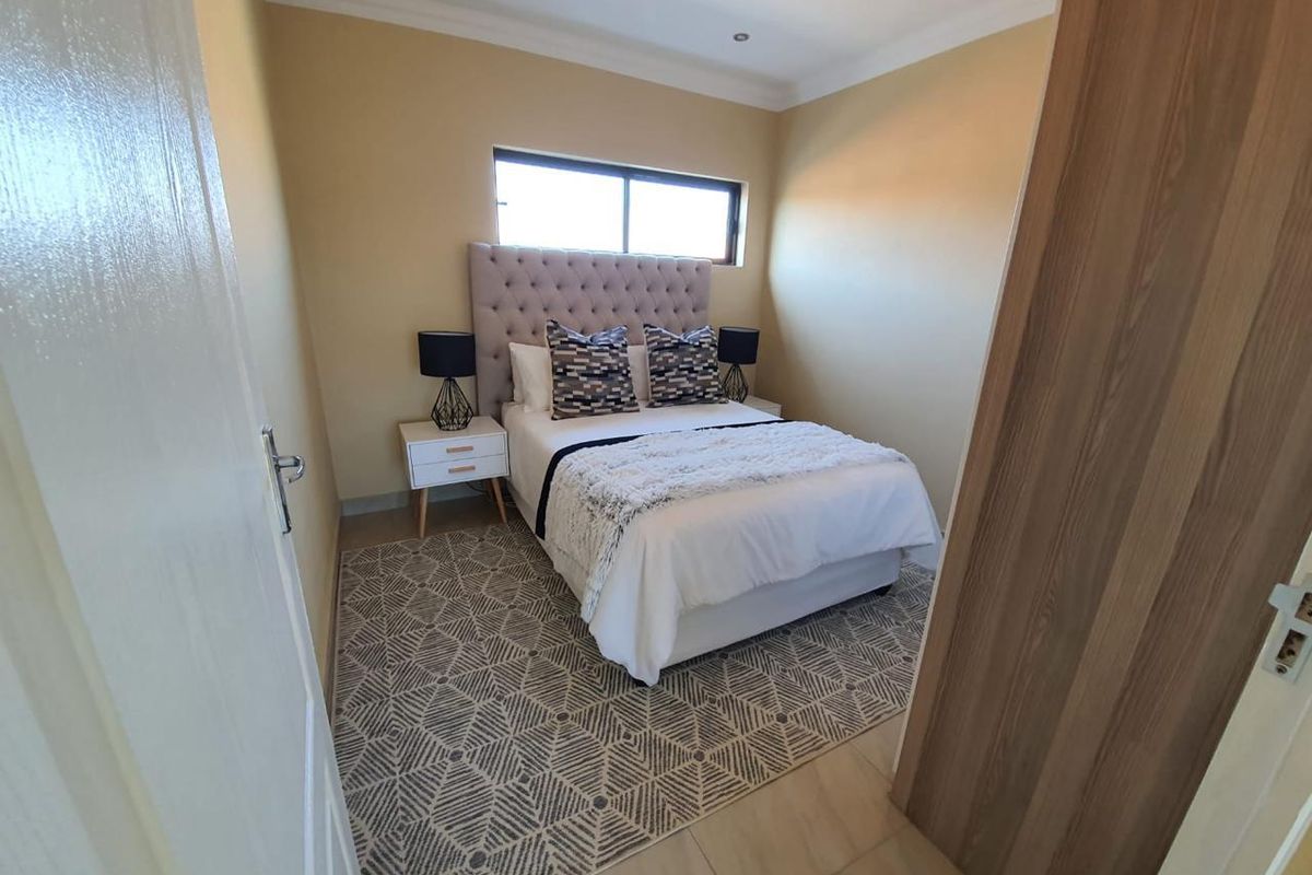 A well-maintained bedroom featuring tiled flooring, recessed downlighting, coving, and a built-in cupboard, offering a clean and functional living space.