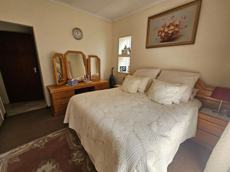 A carpeted bedroom featuring a built-in wall niche and coved ceiling, offering a functional and traditional layout.