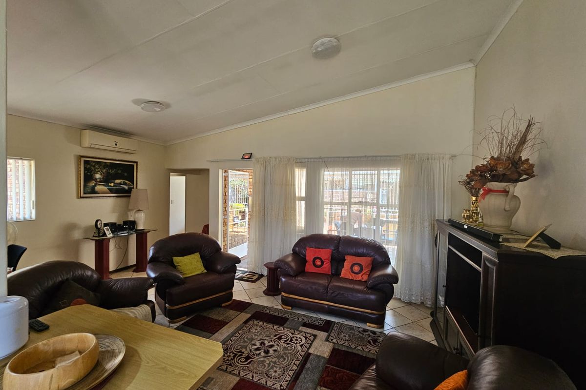 Spacious living room featuring tiled flooring, a split-system air conditioner, and direct access to an outdoor patio area through sliding glass doors.
