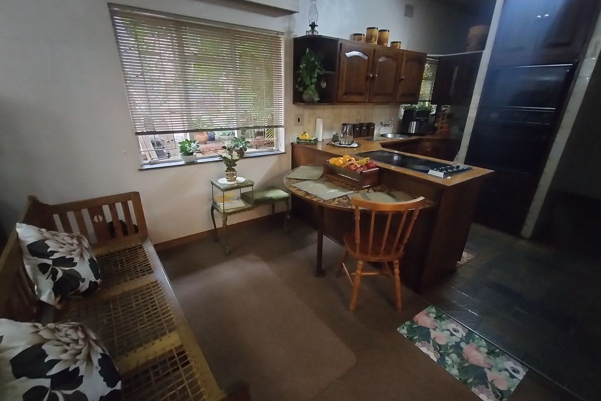 A functional kitchen featuring traditional wooden cabinetry, a built-in oven, and a breakfast nook area with natural light from the window.
