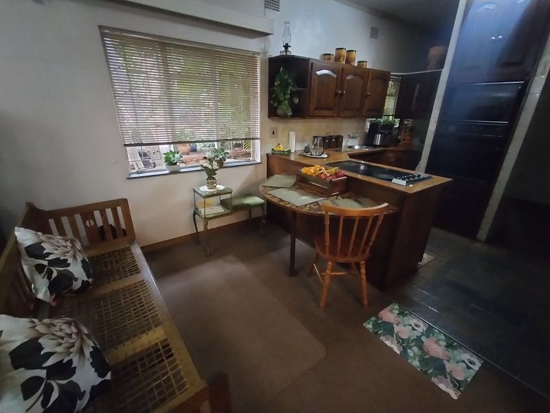A functional kitchen featuring traditional wooden cabinetry, a built-in oven, and a breakfast nook area with natural light from the window.