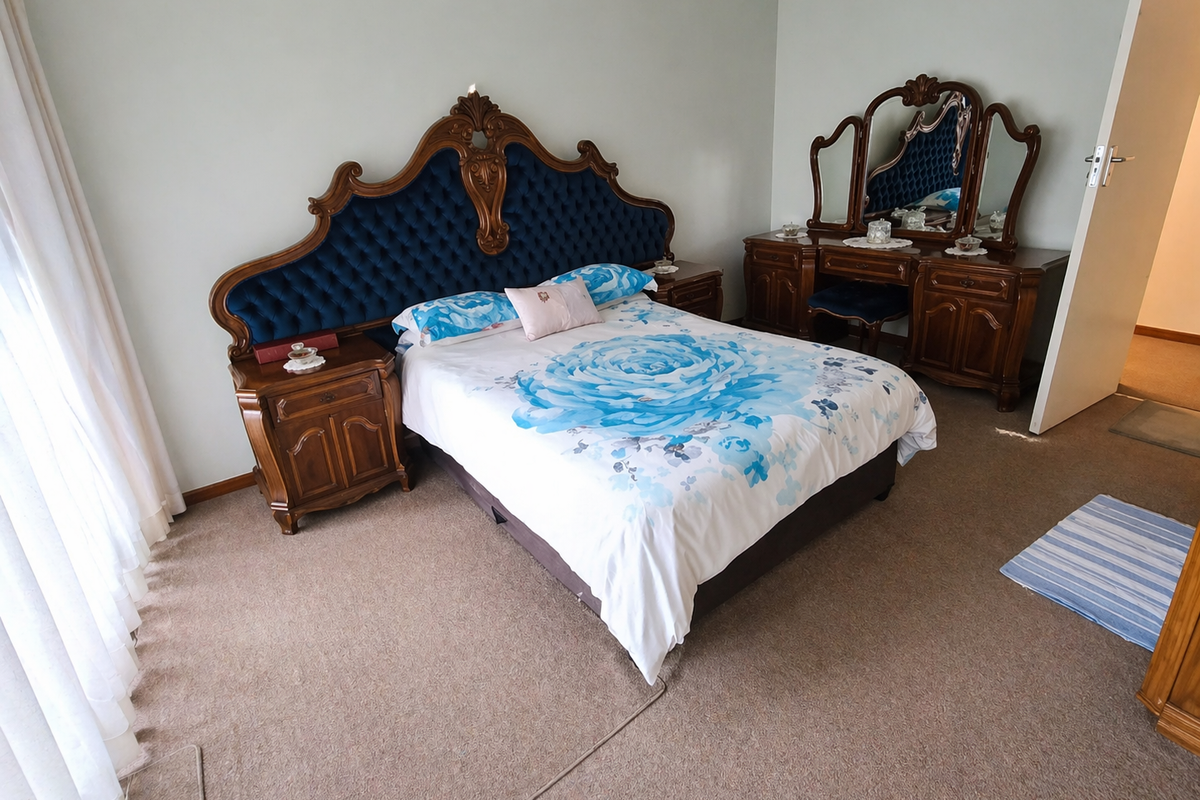 A spacious bedroom featuring neutral wall tones, carpeted flooring, and large windows with curtains, offering a comfortable and functional living space.