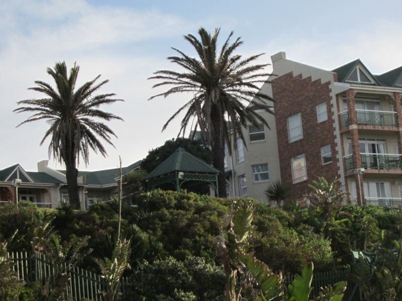 Exterior view of the Brookes Hill Suites and Hotel building, featuring brick facade, multiple balconies, and landscaped grounds.