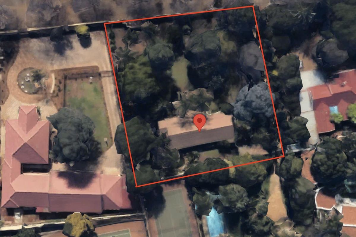 An aerial view showing the property boundary, roof structure, and surrounding mature garden vegetation.