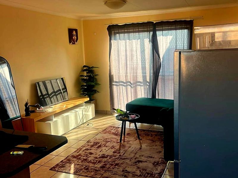 Open plan living area featuring tiled flooring and a sliding glass door providing access to the exterior.
