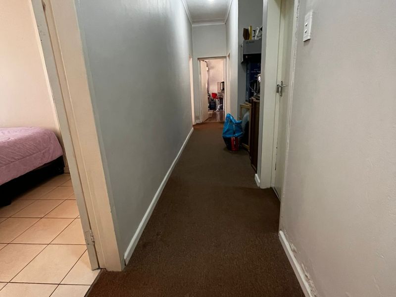 A functional hallway connecting multiple rooms, featuring carpeted flooring and neutral wall finishes, providing access to the rest of the home.