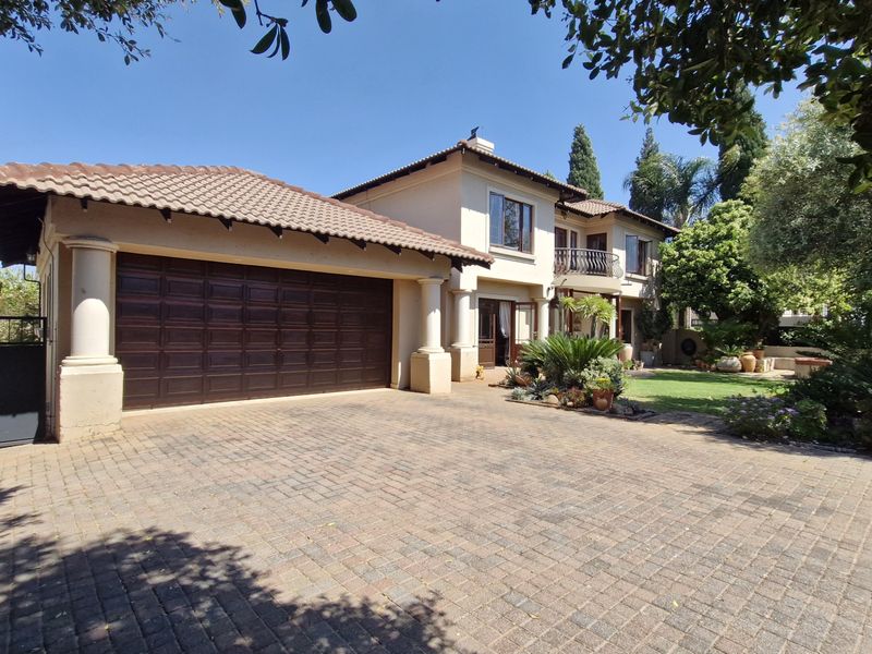 A well-maintained double-story residential property featuring a paved driveway, double garage, and an upper-level balcony with a classic tiled roof design.
