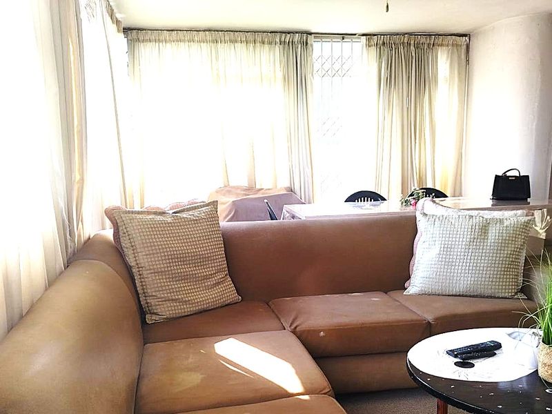 A living room area featuring large windows that allow for ample natural light, providing a bright and open atmosphere.