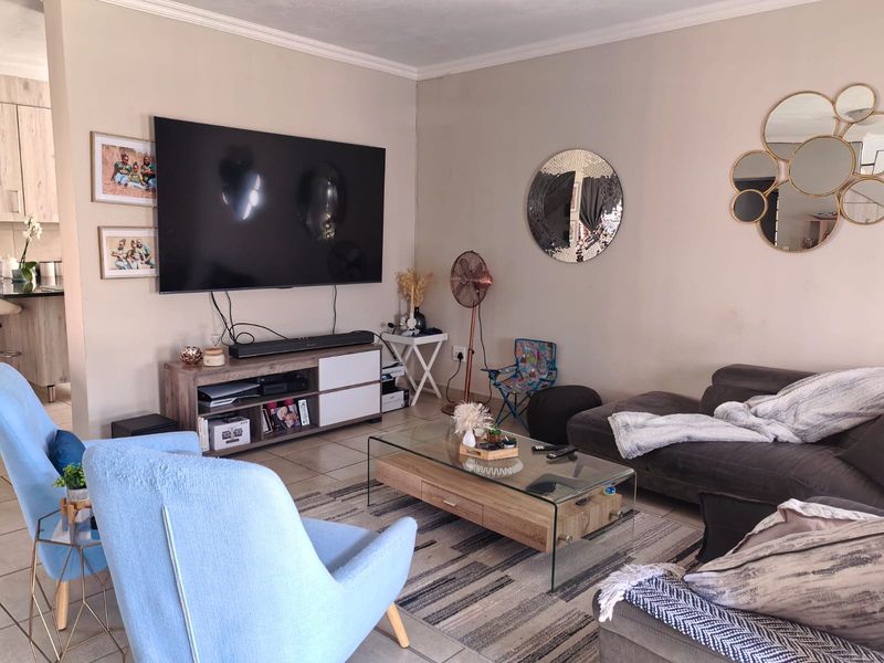 A comfortable living room featuring tiled flooring and coved ceiling details, providing a functional and inviting space for relaxation.
