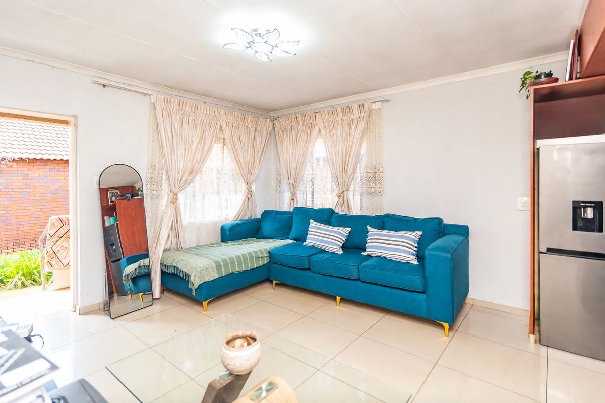 A bright living room featuring tiled flooring and natural light, providing a comfortable and functional space for relaxation.