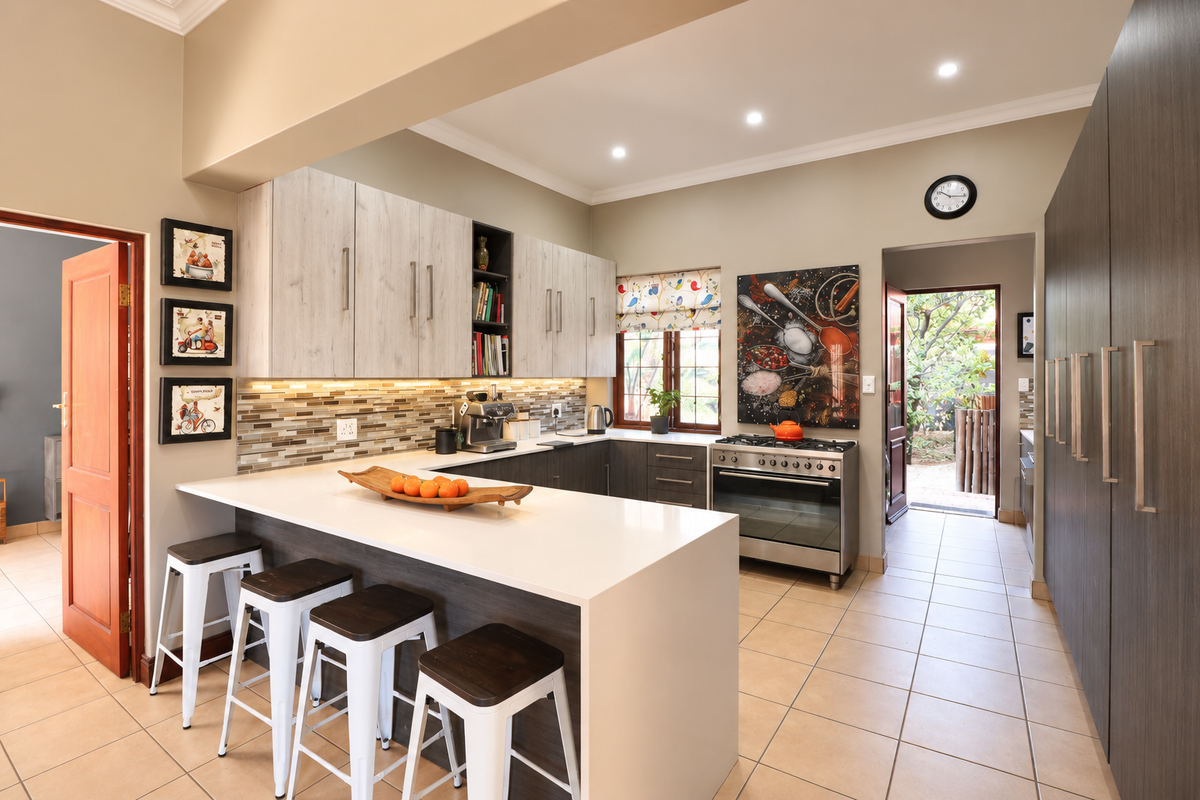 Modern kitchen featuring quartz countertops, mosaic tile backsplash, built-in cabinetry, and a gas stove, with direct access to an outdoor area.