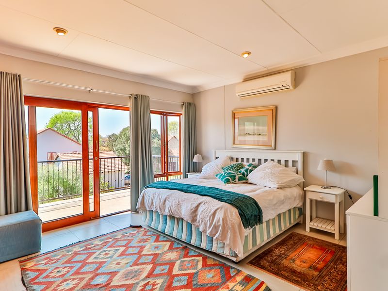 Spacious bedroom featuring tiled flooring, an integrated air conditioning unit, and large sliding glass doors providing direct access to a private balcony.