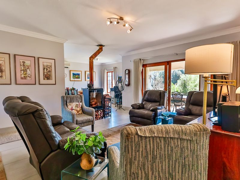 Spacious living room featuring a freestanding fireplace, tiled flooring, and large sliding glass doors providing access to the outdoor patio area.