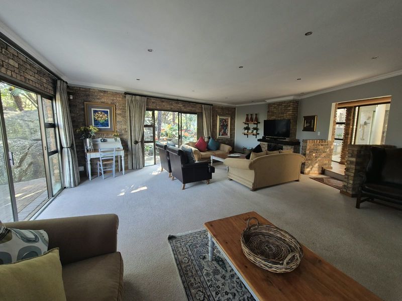Spacious living room featuring a brick fireplace, exposed brick feature walls, and large sliding glass doors providing ample natural light and garden access.
