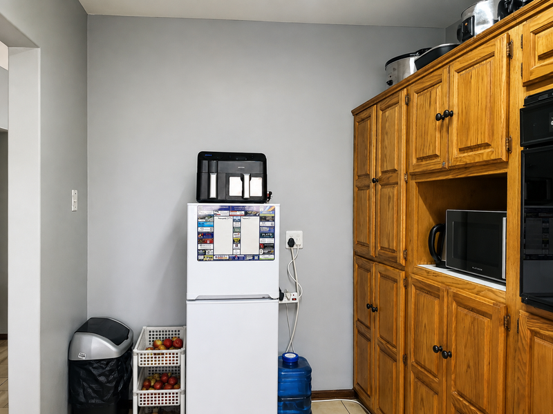 A kitchen area featuring traditional wooden cabinetry with integrated oven and microwave housing, providing ample storage space.