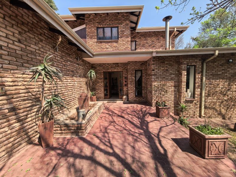 A charming face brick townhouse entrance featuring a private paved courtyard, built-in brick planters, and a classic architectural design.