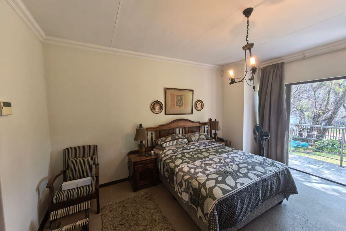A bedroom featuring neutral walls, carpeted flooring, and a sliding glass door providing access to an outdoor patio area.